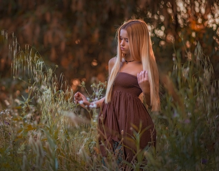 Woman in brown dress in a field of grass