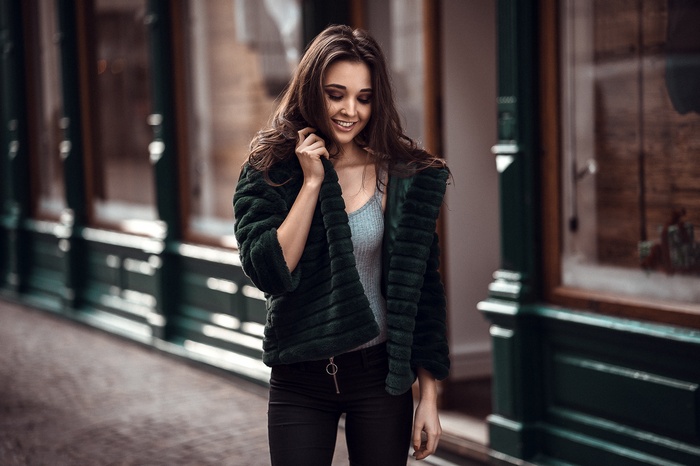 Woman in green fur jacket and black pants