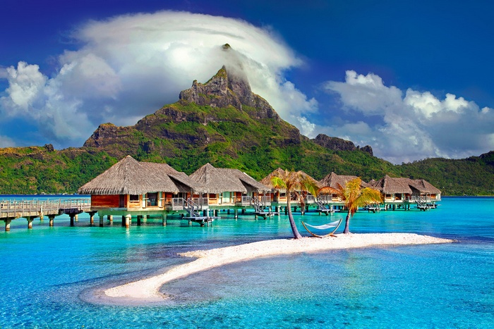 Overwater bungalows in Bora Bora with a mountain backdrop