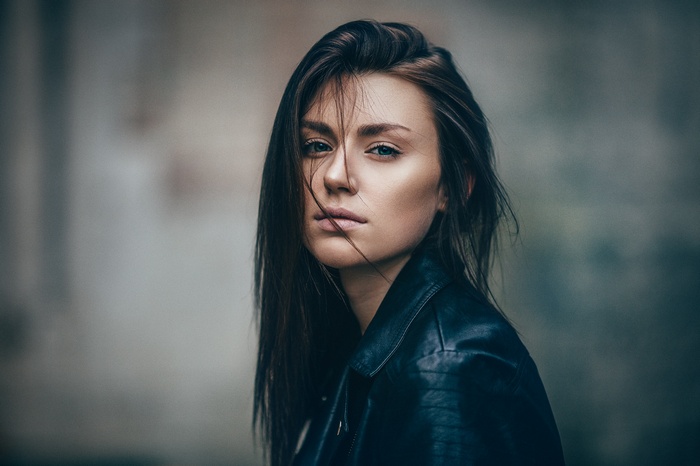 Woman with hair in face wearing leather jacket