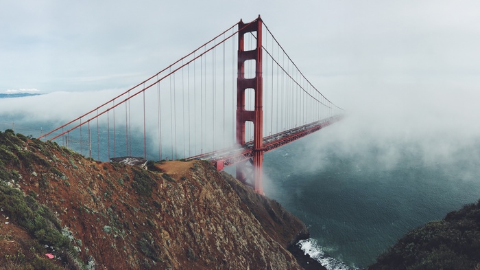 Golden Gate Bridge shrouded in fog over the sea