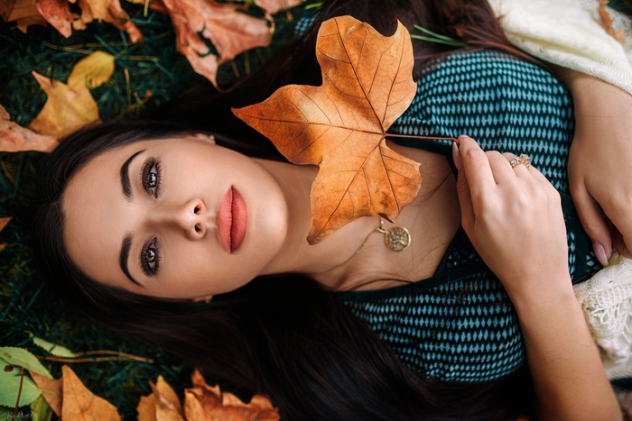 Woman lying down with autumn leaves