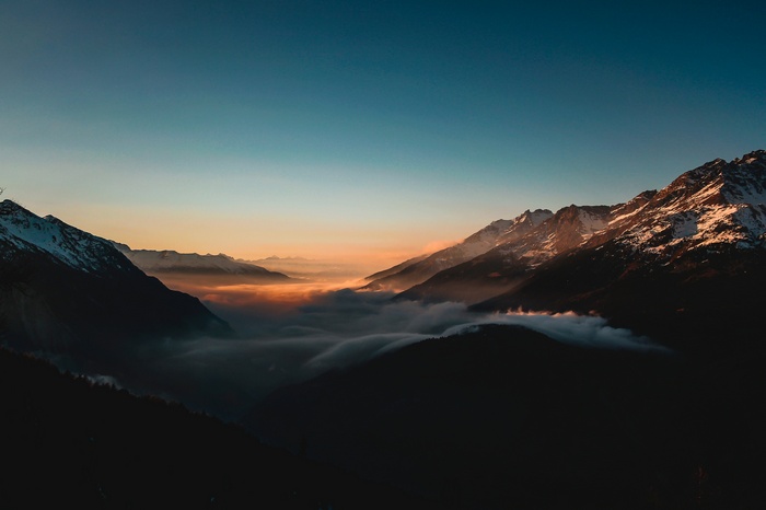 Mountains covered in snow and clouds at sunset