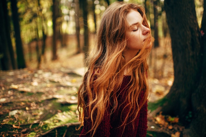 Woman with long red hair in a forest