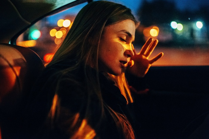Woman in car at night with bokeh lights