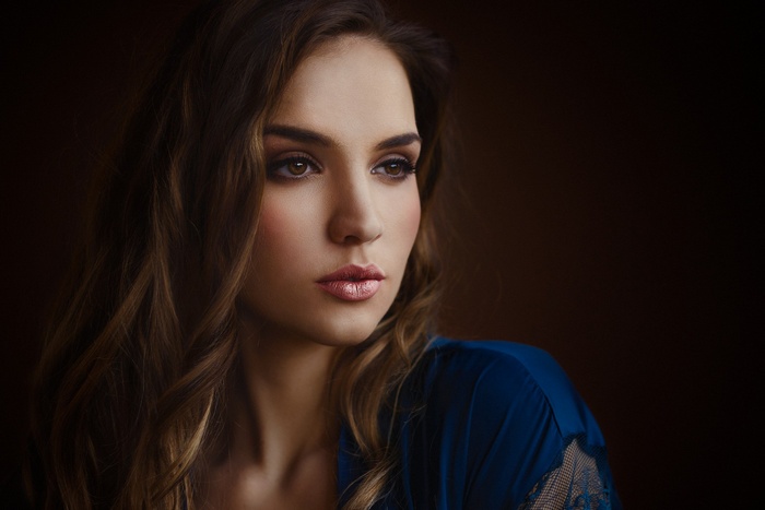 Woman with long brown hair in blue clothing