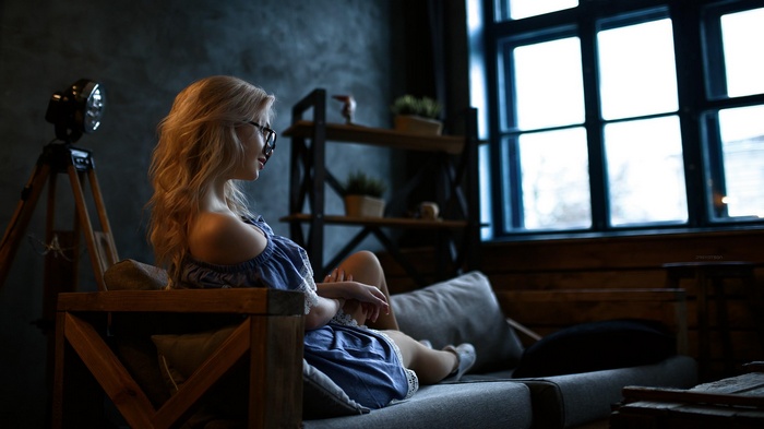 Woman in blue dress sitting on couch