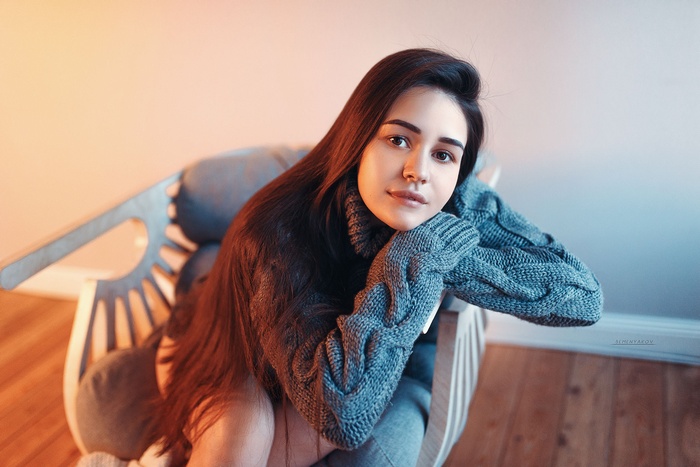 Woman in a gray sweater sitting in a chair