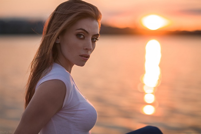 Woman in white top at sunset by the sea