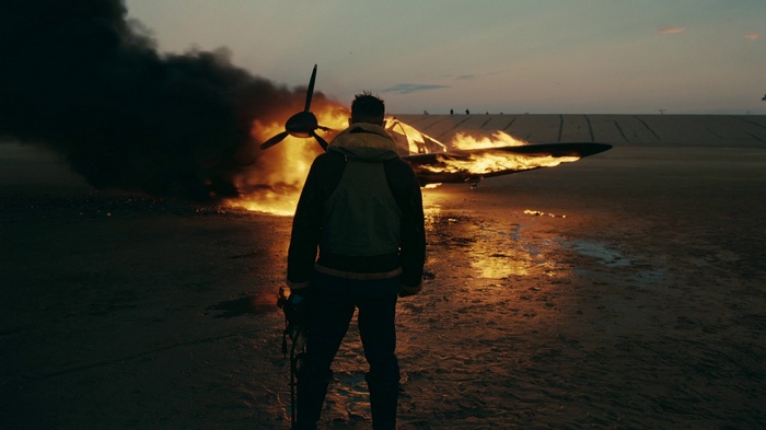 Man standing near burning airplane from Dunkirk
