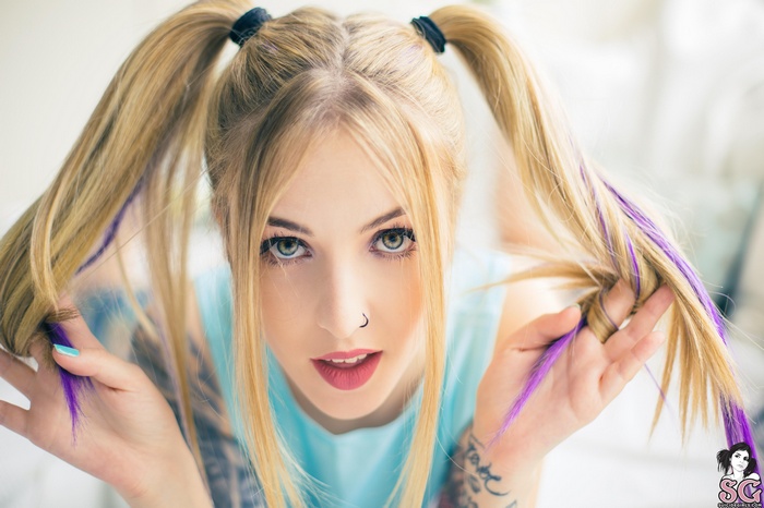 Woman with blonde pigtails and purple streaks