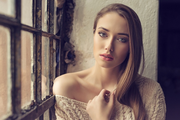 Woman in sweater by a window