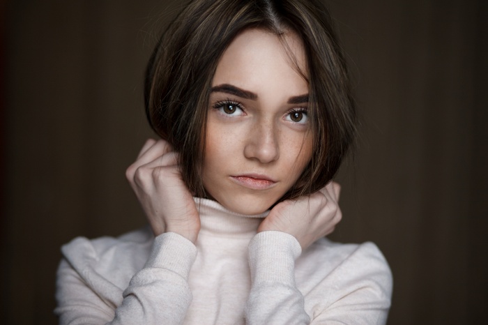 Portrait of a young woman with brown eyes and freckles