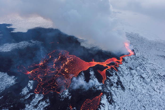 Lava flow in Iceland with snow and smoke