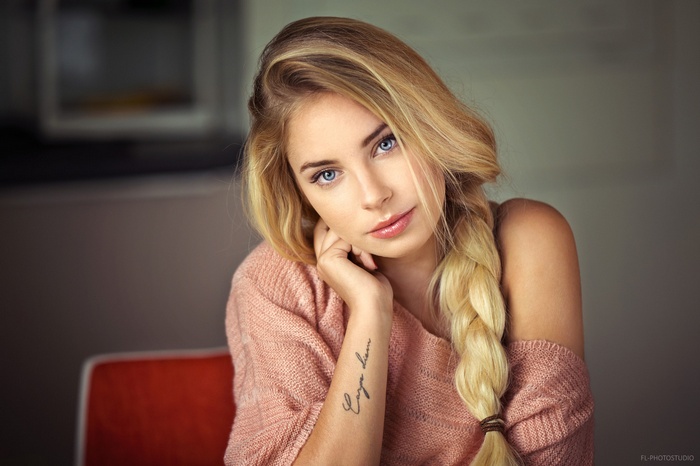 Woman with blonde braided hair and blue eyes