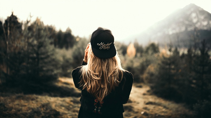 Woman wearing a black cap in a forest