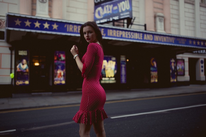 Lily Kate France in red polka dot dress outside theatre
