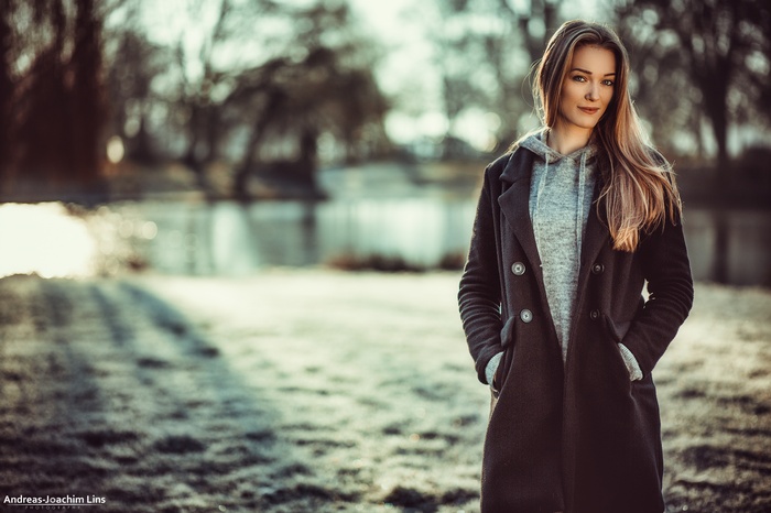 Woman in black coat and grey shirt outdoors