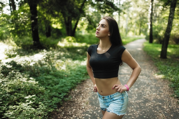 Woman in crop top and jean shorts in a park