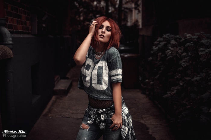 Redhead woman in torn jeans and sports jersey