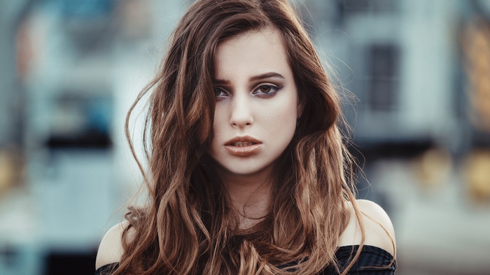 Woman with wavy brown hair and makeup