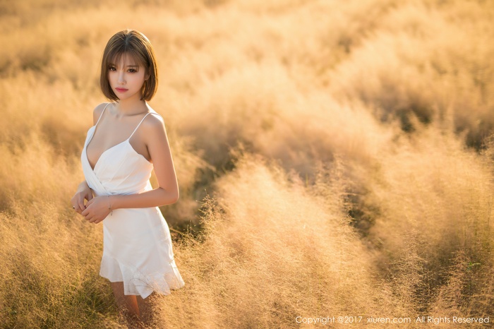 Asian woman with short hair in a white dress in a field