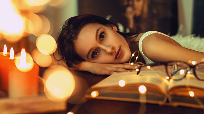 Woman with candles and book by Lukáš Vrábel