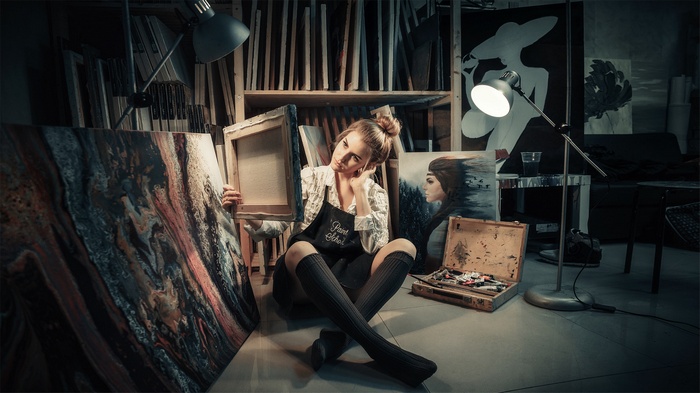 Artist Evgeniya Yurovskih in her studio with paintings