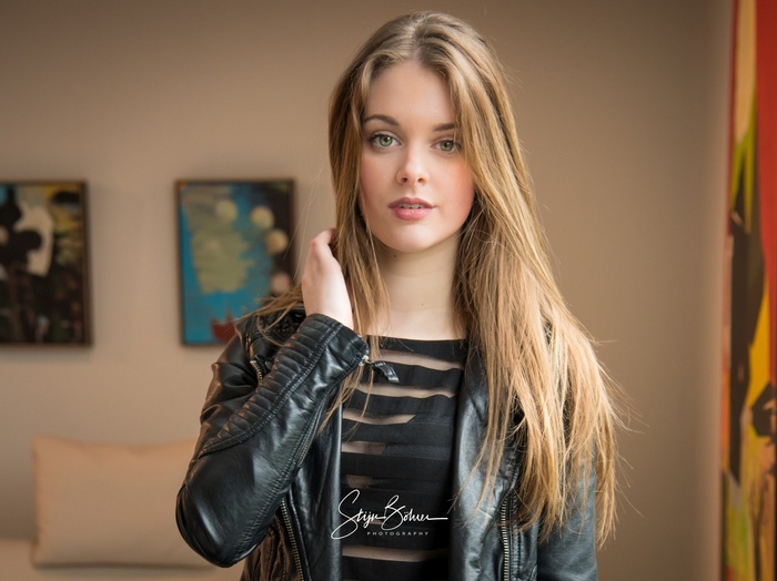 Woman with long blonde hair wearing a leather jacket