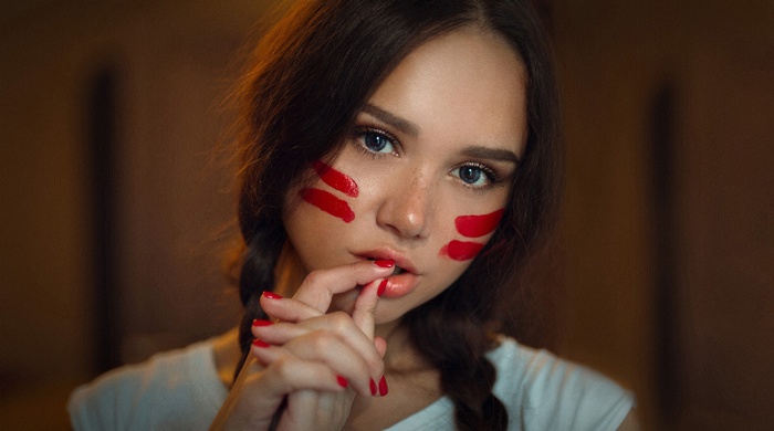Woman with red face paint and braided hair