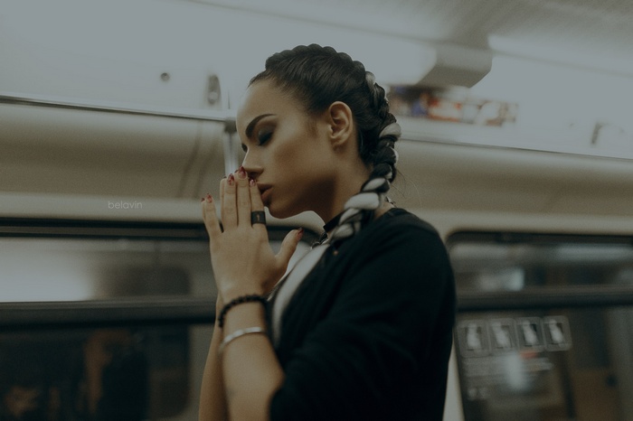 Woman with braided hair praying on a train