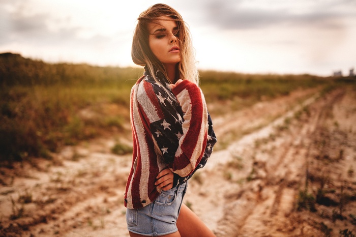 Woman wearing American flag cardigan and jean shorts
