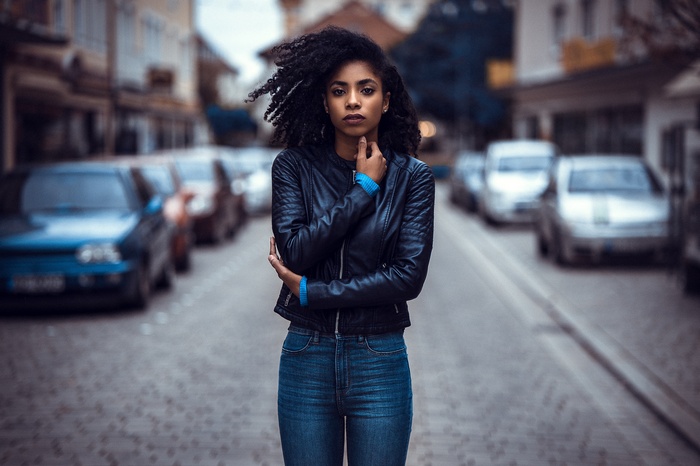 Woman in leather jacket and jeans on street