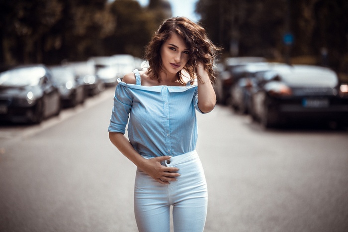 Woman in blue shirt and white pants on street