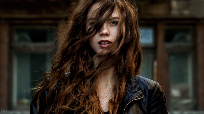 Woman with windblown hair and leather jacket