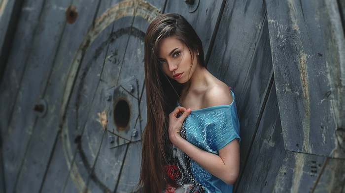 Woman with long brown hair in a blue shirt