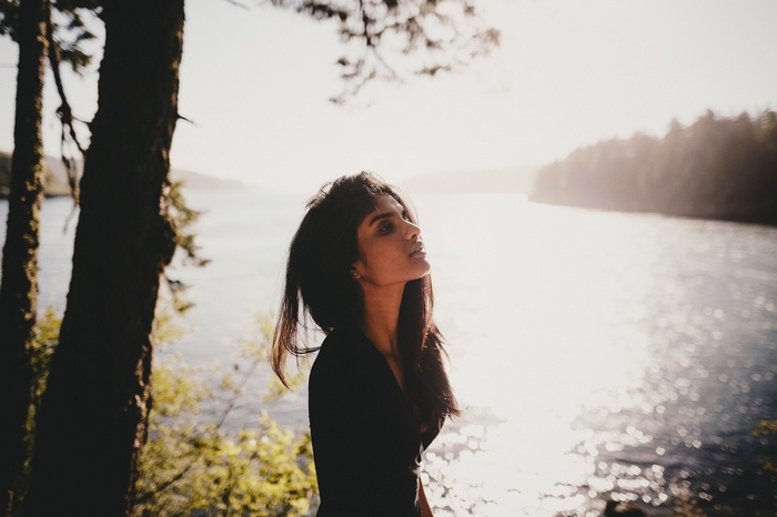 Woman looking up by a lake