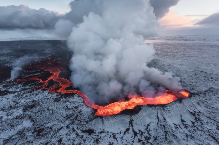 Lava flow in Iceland with snow and smoke