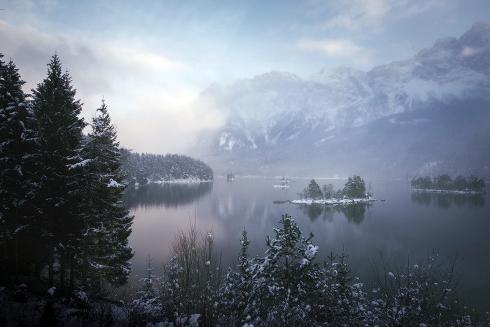 Winter landscape with snow-covered mountains and a lake