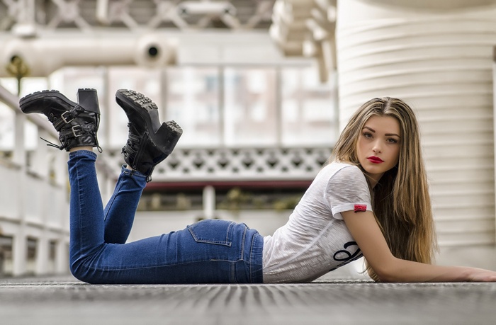 Woman in jeans and boots lying down