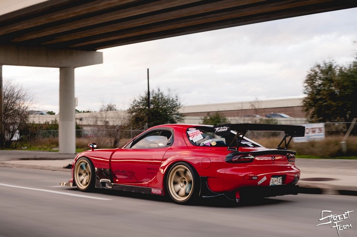 Red Mazda RX-7 sports car with large rear wing