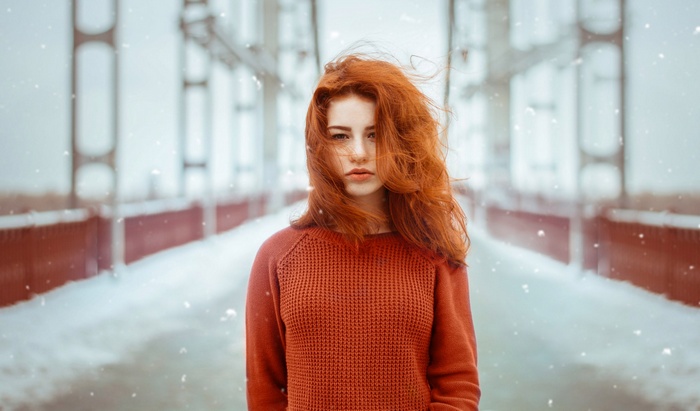 Redhead woman on a snowy bridge