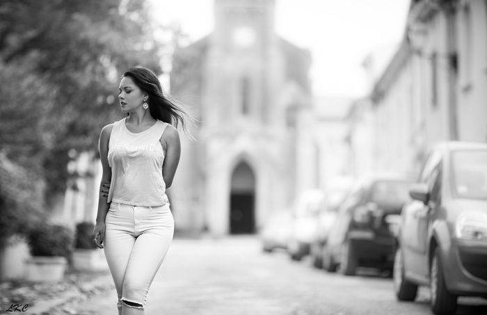 Woman in torn jeans walking down a street