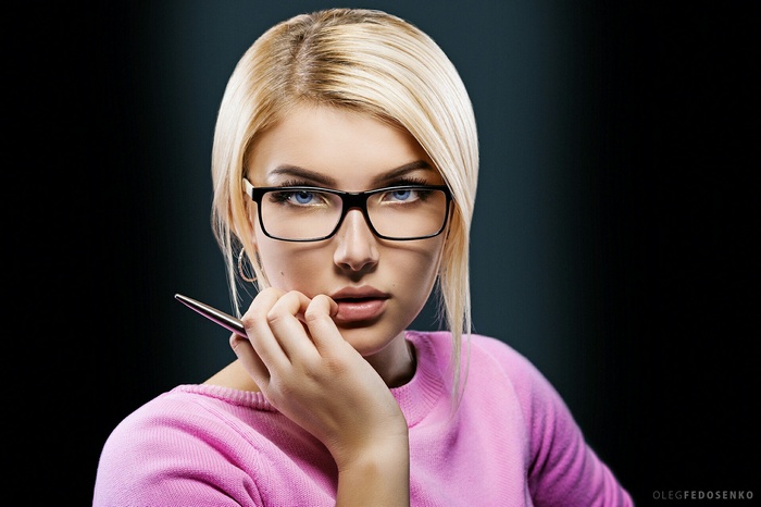 Woman with glasses holding a pen