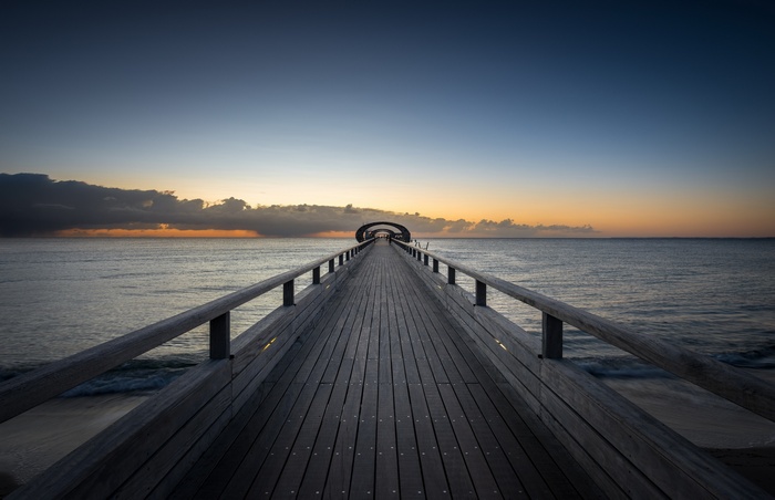 Wooden pier over the sea at sunset