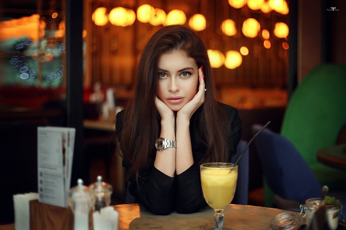 Portrait of a woman with long brown hair and red nails