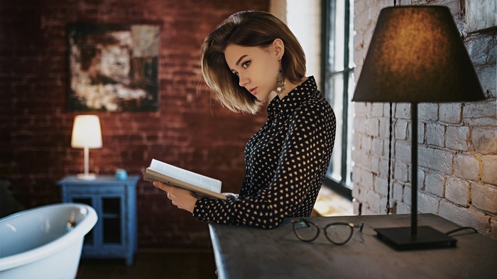 Nastya Gorbachyova reading a book by a lamp