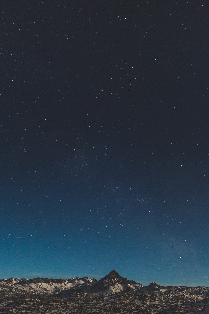Starry night sky over snow-capped mountains