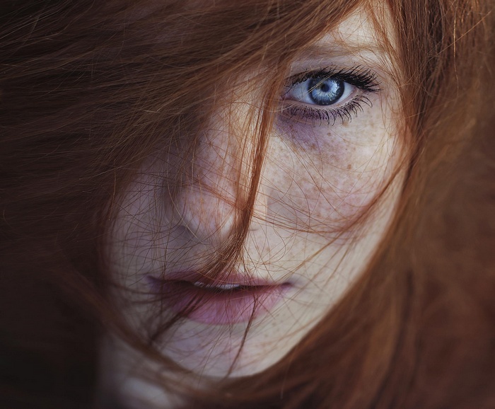 Close-up of a redhead woman with blue eyes and freckles