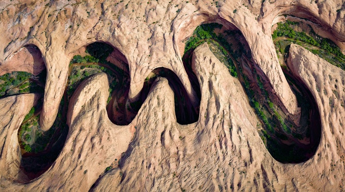 Aerial view of a winding canyon with green vegetation